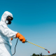 exterminator in protective uniform holding toxic spray outside - Sorglos Bauen GmbH
