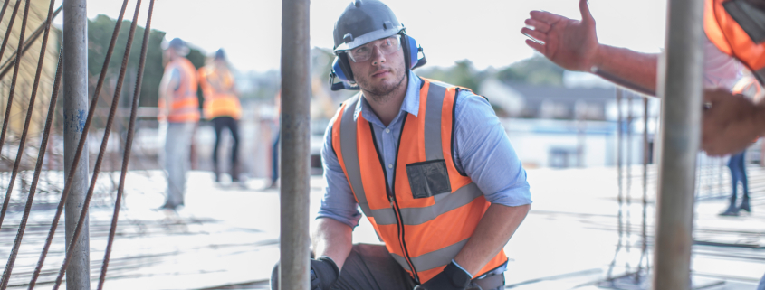 Site manager explaining to builder on construction site - Sorglos Bauen GmbH