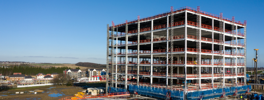 A new build skyscraper building surrounded by scaffolding - Sorglos Bauen GmbH