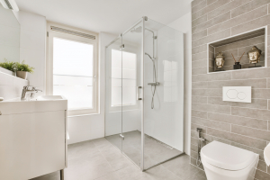 a white bathroom with a shower and a toilet - Sorglos Bauen GmbH