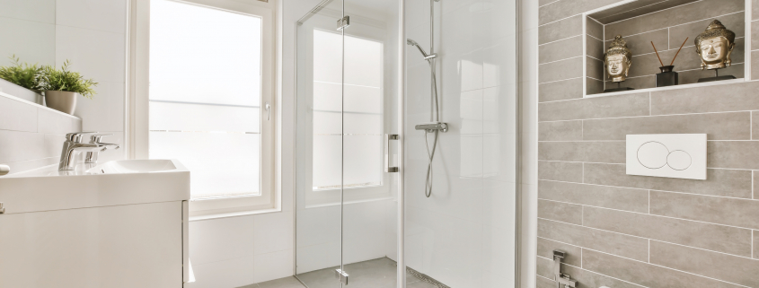 a white bathroom with a shower and a toilet - Sorglos Bauen GmbH