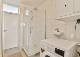 a laundry room with a washing machine and a shower - Sorglos Bauen GmbH - Sorglos Bauen GmbH