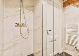 a marble bathroom with a shower and a sink - Sorglos Bauen GmbH - Sorglos Bauen GmbH