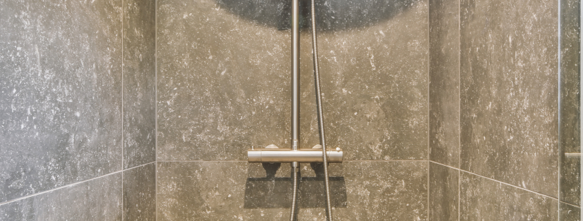 Open shower in gray tiled room - Sorglos Bauen GmbH