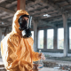 Portrait of man dressed in chemical protection suit that is in the ruins of the post apocalyptic building - Sorglos Bauen GmbH