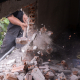Unrecognizable builder using a sledgehammer breaking and smashing the wall fallen into debris - breaking wall and challenges concept - Sorglos Bauen GmbH